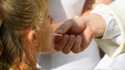priest-giving-communion-to-a-young-girl